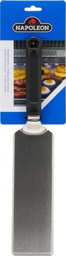 The Napoleon Griddle Spatula for Griddles (GATL014) by Napoleon Grills features stainless steel, a black heat-resistant handle, and comes packaged on a blue and white Napoleon card with grilled food images in the background.