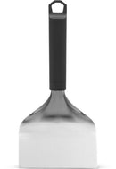 The Napoleon Griddle Scraper for Griddles (GATL016) by Napoleon Grills features a wide, flat stainless steel blade and a black handle, shown upright against a white background.