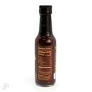 A bottle of Powerful Pepper Chipotle Ghost & Black Garlic Hot Sauce from the Powerful Pepper Company, topped with a black cap and displaying a nutrition facts label and ingredients list on the back. The dark reddish-brown sauce is visible inside, and the image is set against a white background.