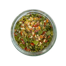 A glass jar of SALTOPIA Infused Sea Salts' Saltopia Garden Herbs & Lemon Seasoning, featuring a colorful mix of green, red, yellow, and white herbs and spices, is viewed from above on a white background.