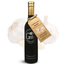 A bottle of Georgetown Olive Oil Co. Garlic Infused | High Polyphenols Extra Virgin Olive Oil, distinguished by its brown label, is displayed in front of two garlic bulbs and a single garlic clove on a white background. This premium offering from Georgetown Olive Oil Co. delivers bold California flavor and aromatic richness to your kitchen.