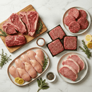 An assortment of premium raw meats from the Dude Food Gentleman’s Meat Box by Dude Food—including Boneless Chicken Breasts, Kansas City Strip Steaks, hamburger patties, American Ground Beef, and pork chops—garnished with herbs, lemon slices, salt, and pepper, all elegantly arranged on a white marble surface.
