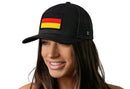 A smiling person wears a Haka Hat German Flag Trucker Hat | Black Germany Snapback by Haka Hat, featuring an embroidered Germany flag patch on the front, against a white background.