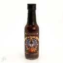 The Powerful Pepper Company’s Chipotle Ghost & Black Garlic Hot Sauce comes in a brown bottle with a black cap and a label featuring an owl/dragon, pyramid, and text. Made with chocolate ghost peppers for bold, smoky heat.