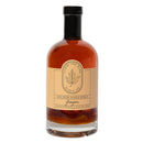 A clear glass bottle of Under The Bark Syrup Co Ginger Maple Syrup with a black cap and beige label featuring a maple leaf illustration and product details.