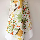 The Gingiber Garden Chicken Tea Towel by Gingiber is a white cotton kitchen towel with colorful prints of potted tomato plants, garden tools, chickens, and herbs in green, red, yellow, and brown tones.