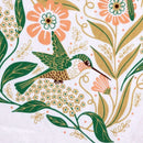 This Gingiber Hummingbird Tea Towel features a green hummingbird among peach and white flowers with green leaves, all in a folk art style—perfect as decorative kitchen decor from Gingiber.