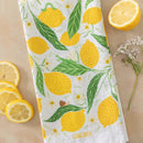 The Gingiber Lemon Grove Tea Towel features yellow lemons, green leaves, and lemon blossoms on soft flour sack cotton, bringing a cheerful touch to your kitchen.