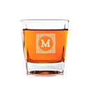 A clear Whiskey Glasses: Heirloom personalized whiskey glass filled with amber liquid, featuring a decorative square frame etched with the letter M.