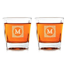 Two Whiskey Glasses: Heirloom filled with amber liquid, each engraved with a decorative square border and the letter M.