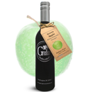 A dark glass bottle of Georgetown Olive Oil Co. Green Apple White Balsamic, expertly crafted in Modena, Italy and featuring a green apple tag, stands in front of a large, translucent green apple backdrop.