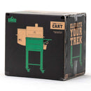 A sleek black box shows the Green Mountain Grills logo, "Trek Prime Cart," and "Elevate Your Trek," with a graphic of the Green Mountain Grills Trek Cart 2.0—an outdoor grill cart in green and tan with wheels.