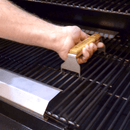 Using the Smokin Brothers Grid Lifter, a person safely removes the grates of a barbecue grill for thorough cleaning and maintenance. This essential tool from Smokin Brothers pairs perfectly with their other accessories, making it easy to keep your grill in top condition.