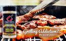 A jar of Butcher BBQ Grilling Addiction BBQ Rub Seasoning by Butcher BBQ sits beside tongs flipping meat on a smoky grill, with the bold text, “Grilling Addiction? We know you!”.