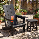 A DirectDeals Adirondack Chair with Cup Holder - HDPE Outdoor Seating sits on a stone patio with a pink drink, next to a matching side table, surrounded by potted plants and blooming flowers.