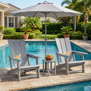 Two gray DirectDeals Adirondack Chair with Cup Holder - HDPE Outdoor Seating and a small table with fruit sit poolside under an umbrella, each chair holding a colorful tropical drink. Palm trees and a house are in the background.