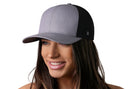 A woman smiles wearing a Haka Hat Blank Trucker Hat | Snapback in grey and black, featuring an H logo on the side and a comfort-fit sweatband for all-day ease.