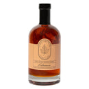 Under The Bark Syrup Co Habanero Maple Syrup is an amber syrup with visible habanero pieces and a maple leaf illustration, offering sweet heat in every pour.