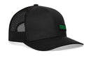 The Haka Hat Black Rubber Patch Snapback is a branded trucker hat with a mesh back, solid front panel, green text on a small rectangular patch, and a comfort-fit sweatband for all-day wear.
