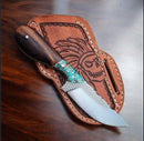 The Texan Knives Handcrafted Belt Knife features an 8" rasp steel blade and turquoise & rosewood handle, resting on a brown leather sheath engraved with a skull in a feathered headdress.