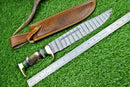 The Texan Knives Custom Handmade Damascus Steel Bowie Knife features a 16" blade and a decorative stag horn handle. Shown with a ruler and brown leather sheath on green artificial grass, this impressive knife is from Texan Knives.