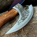 The Texan Knives Custom Hand-Engraved Axe Pizza Cutter features an 8" J2 steel blade with Celtic knot engravings and a wooden handle, displayed on a rustic wood surface.