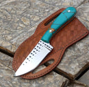 The Texan Knives Handmade Cowboy Knife – 8" Rasp Tool Steel Blade features a turquoise handle and black triangle accents, resting on a basket-weave brown leather sheath by Texan Knives, displayed on a stone surface.