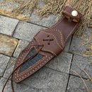 The Texan Knives 🔥 Handmade Damascus Steel Hunting Knife features a rosewood handle, Damascus guard, and a handcrafted brown leather sheath with tan stitching and alligator inlay—shown on stone tile with dried grass.
