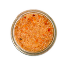 A glass jar of SALTOPIA Infused Sea Salts' Saltopia Hot Honey seasoning blend, featuring orange and yellow hues, seen from above on a white background.