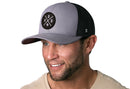 A man wearing a Haka Hat Houston Trucker Hat—Gray-Black HOU X Snapback—with a patch displaying "HOU" and the outline of Texas.