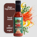 A bottle of Culture Hot Sauce Hungarian Secret by Culture Hot Sauce, labeled as clean ingredients, handmade, and sugar-free. Surrounded by herbs, lemon slices, and red pepper flakes, this Hungarian paprika hot sauce delivers rich flavor with a wholesome touch.