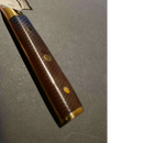 Close-up of the Spaceman Knives Interstellar Kiritsuke Knife handle, featuring a textured reddish-brown surface, two brass rivets, and a brass end cap against a dark background.