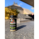 A clear plastic spice shaker of BuffalowBBQ Signature Blend BBQ Rub with a black label featuring cartoon animals, sitting on a stone countertop outdoors.