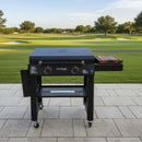 A BBQ Boards® 30" Blackstone Griddle Side Cutting Board sits beside a black outdoor grill on a tiled patio, overlooking a golf course with lush grass, trees, and sand bunkers in the background.