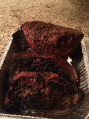 Three large pieces of beef seasoned with BuffalowBBQ Beef Bark BBQ Rub, featuring a dark, flavorful bark formation while sitting in a foil tray.