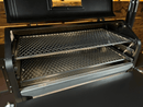 Two metal grate racks from the Pimp My Grill® Gen2 Slide-Out Rack System for Green Mountain Grills Peak / Jim Bowie installed inside a pellet smoker, with the top rack partially pulled forward to increase cooking space.