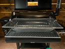 Two stacked, stainless steel diamond-pattern Pimp My Grill® Gen2 Slide-Out Rack System racks installed inside a pellet smoker to maximize cooking space with the lid open.