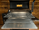 Two metal Pimp My Grill® Gen2 Slide-Out Rack System - 2 Racks installed inside an open pellet smoker cooking space.