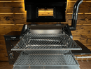 Two metal slide-out grill racks from the Pimp My Grill® Gen2 Slide-Out Rack System for Green Mountain Grills Ledge / Daniel Boone installed as a dual-level cooking system inside a pellet grill with the lid open.