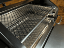 Two stacked metal wire slide-out grill racks from the Pimp My Grill® Gen2 Slide-Out Rack System inside a pellet grill, forming a dual-level cooking system.