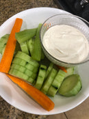 A bowl of sliced carrots, cucumber slices, and celery sticks served with a small glass dish of creamy Bacon Ranch dressing seasoned with BuffalowBBQ Bacon Ranch BBQ Rub.