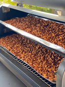 Two stacked trays of almonds coated in BuffalowBBQ Bacon Ranch BBQ rub inside a smoker.