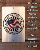 Metal sign with 'Made in the USA' design on a wooden background