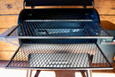 Two Pimp My Grill® Gen2 Slide-Out Rack System metal wire racks extend outward from the open lid of a Traeger Ironwood 885 pellet grill.