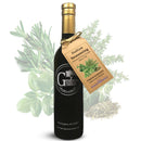 A bottle of Georgetown Olive Oil Co ITALIAN SEASONING | High Polyphenols Extra Virgin Olive Oil from Georgetown Olive Oil Co., distinguished by its gold cap and hanging tag. This cold-infused extra virgin olive oil blends premium quality with an aromatic profile, highlighted amidst fresh herbs and dried seasonings.