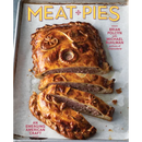 A flaky crust meat pie cut into slices on a baking sheet, displayed next to the Meat Pies: An Emerging American Craft - Hardcover cookbook.