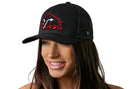 A woman with long brown hair smiles while wearing the Haka Hat JBR x Haka Red Bison Black Buffalo Snapback by Haka Hat, featuring a red and white buffalo patch. The background is plain white.