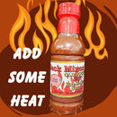 A bottle of Myron Mixon's Jack Mixon's Old South Hot Bar-B-Que Sauce sits amid flames. Bold white text says ADD SOME HEAT. The label shows red and yellow text with a Good Stuff badge.
