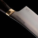 Close-up of the Messermeister Kawashima Chef's Knife - 8", featuring an ergonomic wooden handle, brass bolster, and high-carbon stainless steel blade with the Messermeister name and Japanese characters, set against a black background.