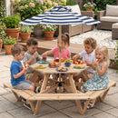 Five kids enjoy snacks and fruit around the Kids Hexagonal Picnic Table with Umbrella and 6 Benches by DirectDeals in a garden, surrounded by potted plants and patio furniture.
